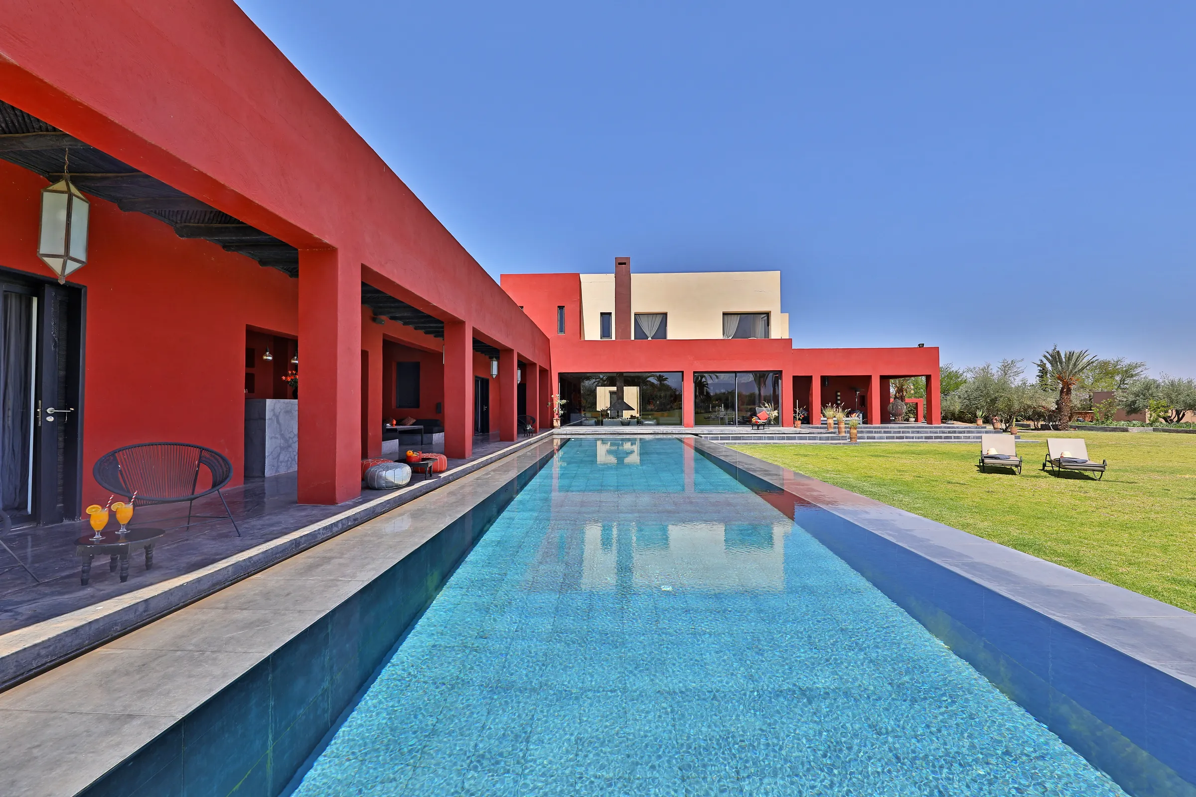Villa Iliana, private villa rental on the Route de l'Ourika, Marrakech: long swimming pool running along the red and white villa