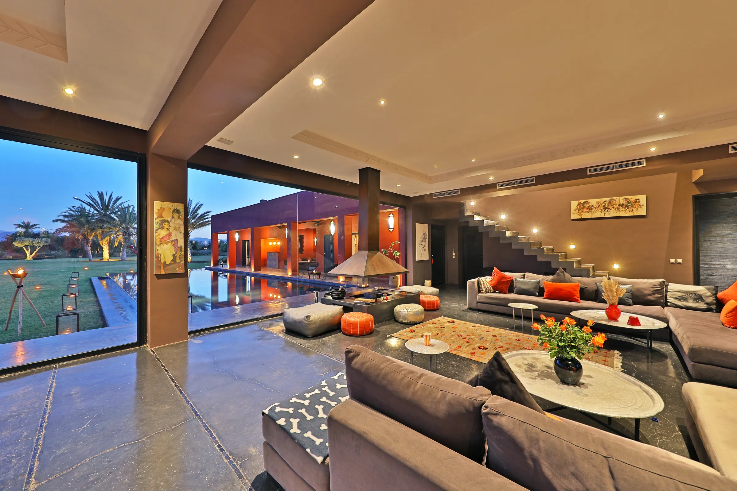 Villa Iliana, private villa rental on the Route de l'Ourika, Marrakech: living room opening onto the pool in the evening