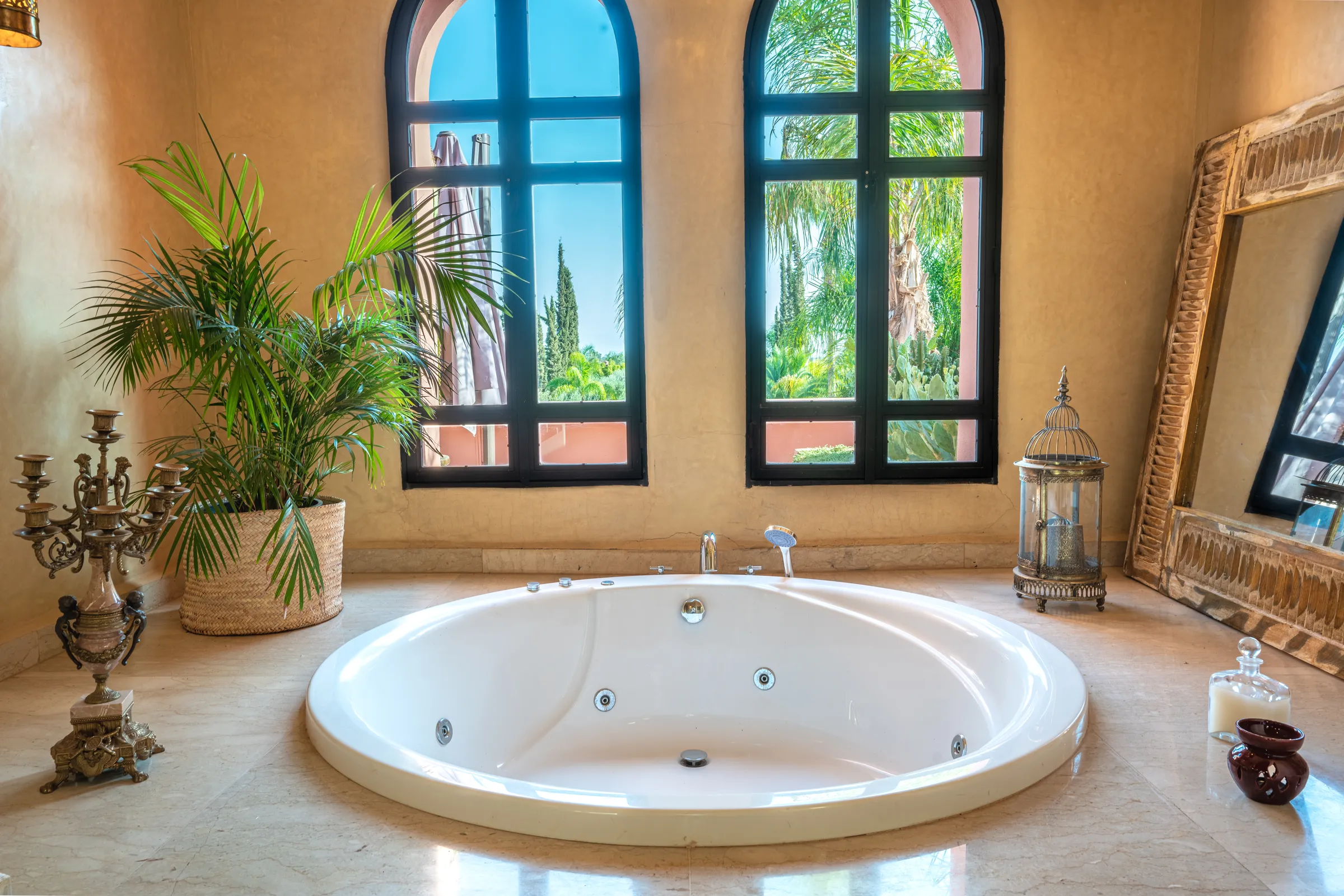 Villa Lyra, private villa rental in Ouled Hassoune, Marrakech: bathroom with round jacuzzi under arched windows