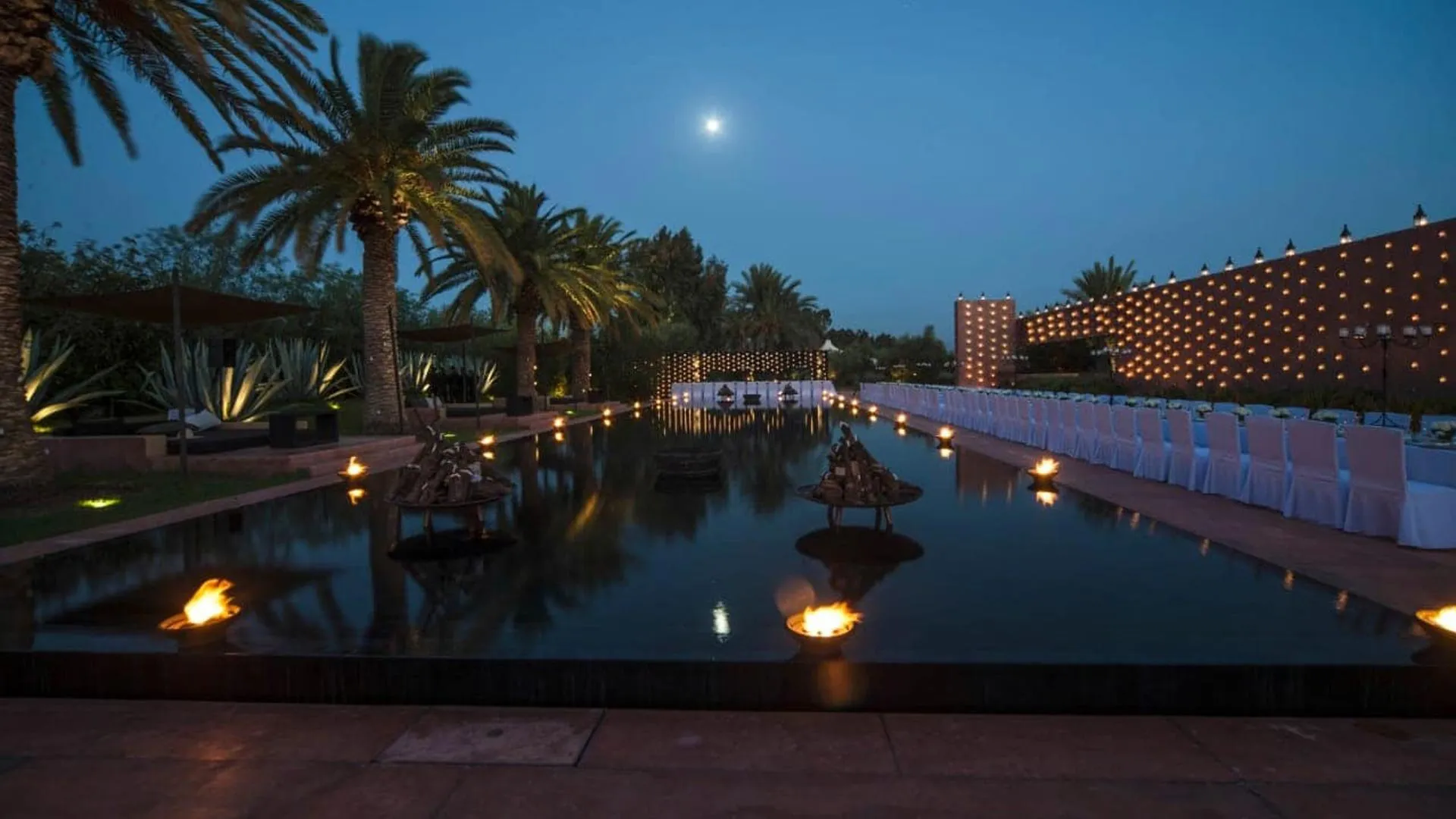 Villa Phaedra, private estate rental in Ouled Hassoune, Marrakech: pool and palm trees at dusk