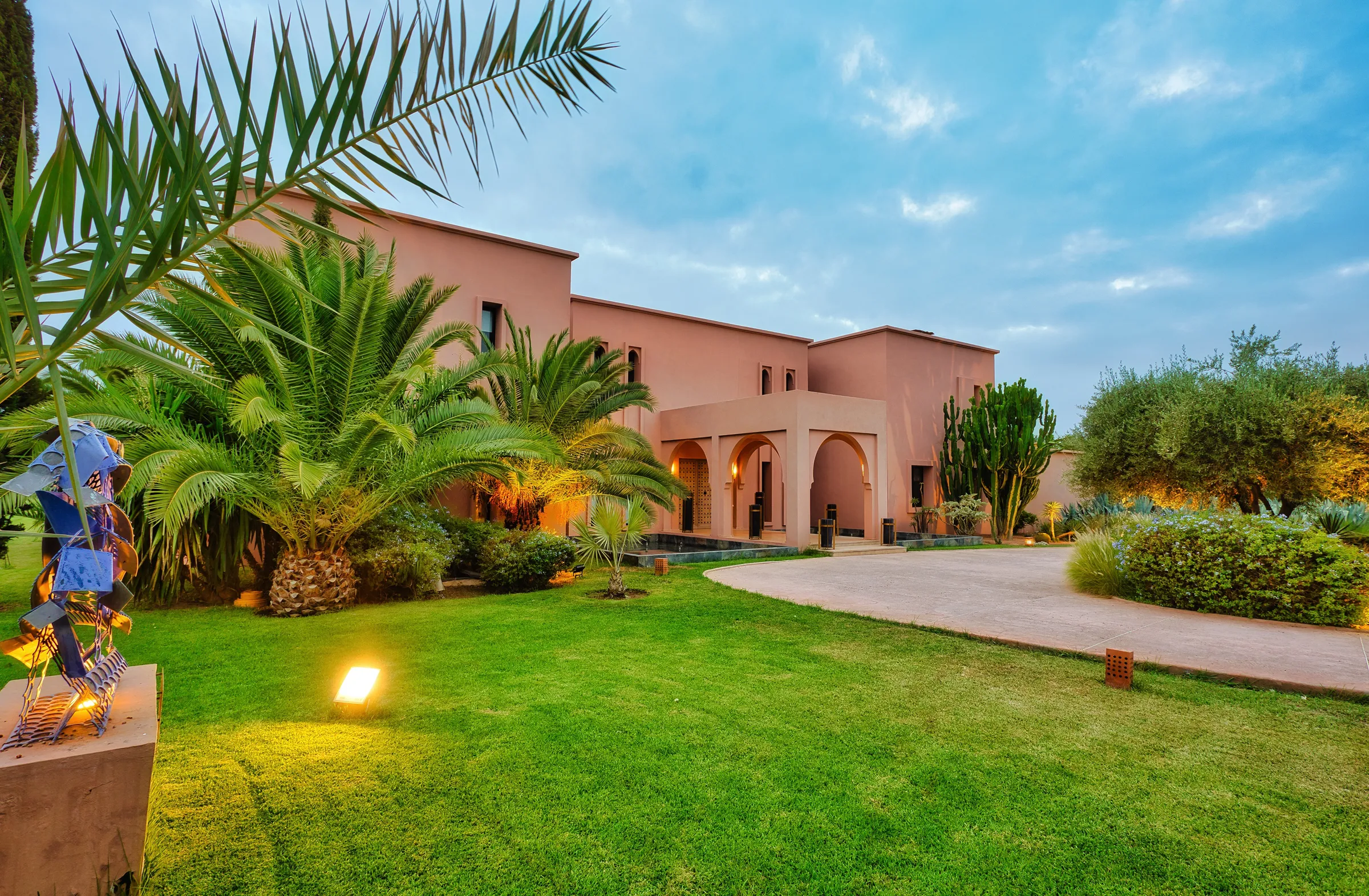 Villa Theia, private villa rental on the Route de l'Ourika, Marrakech: north facade and landscaped garden with palms and olive trees