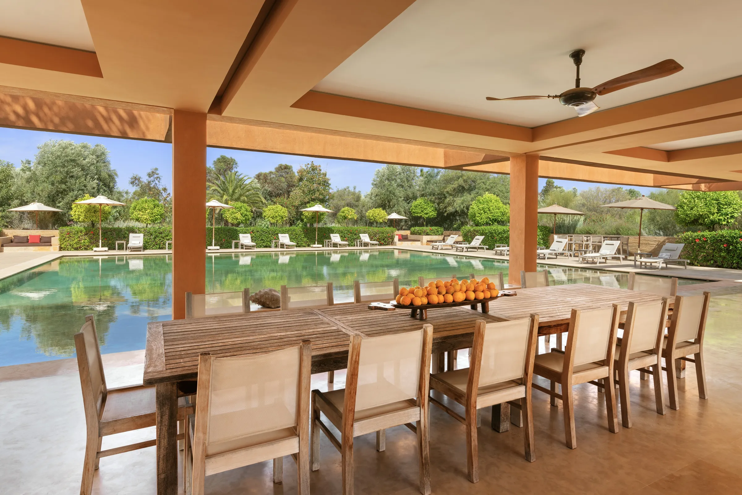 Villa Hera, private estate rental in the Ourika Valley near Marrakech: shaded dining table overlooking the pool