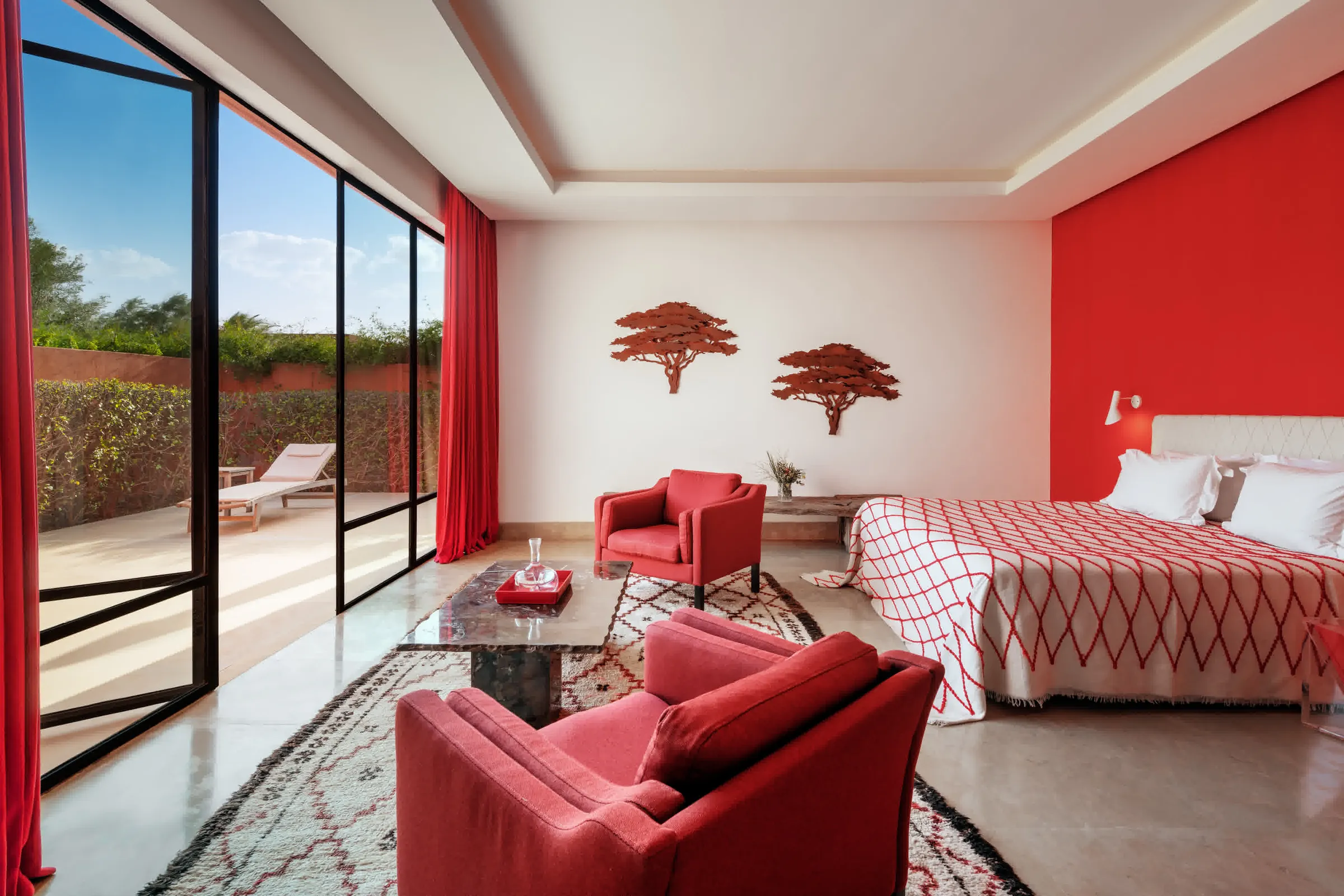 Villa Hera, private estate rental in the Ourika Valley near Marrakech: suite with red armchairs and sliding glass doors