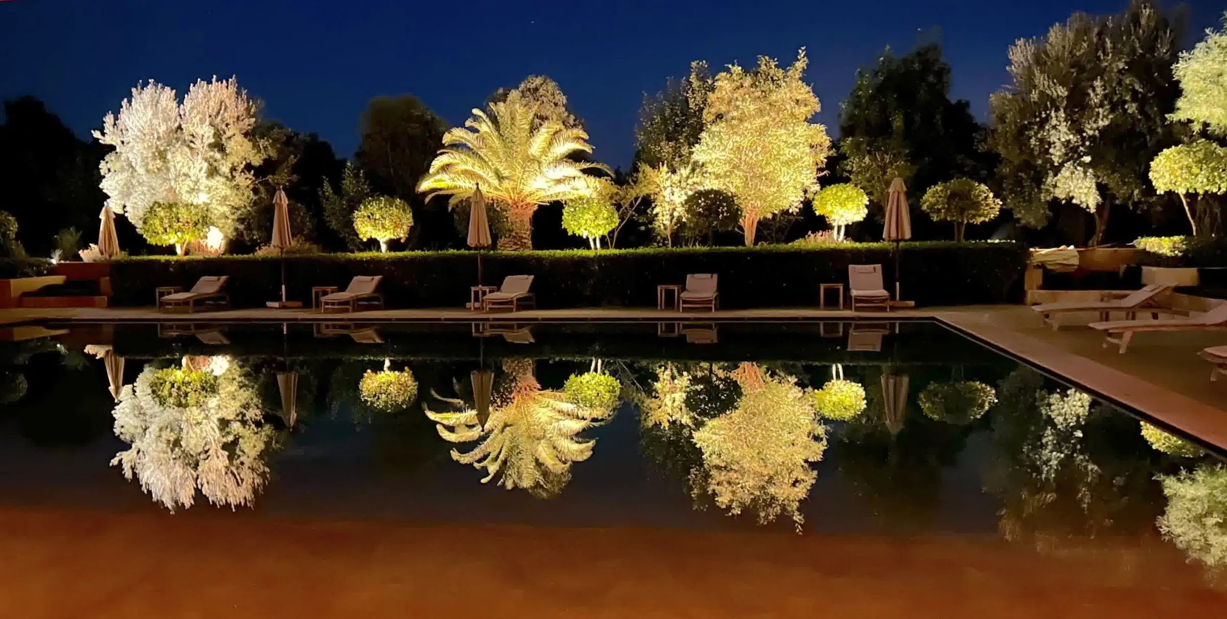 Villa Hera, private estate rental in the Ourika Valley near Marrakech: pool and palm trees illuminated at night