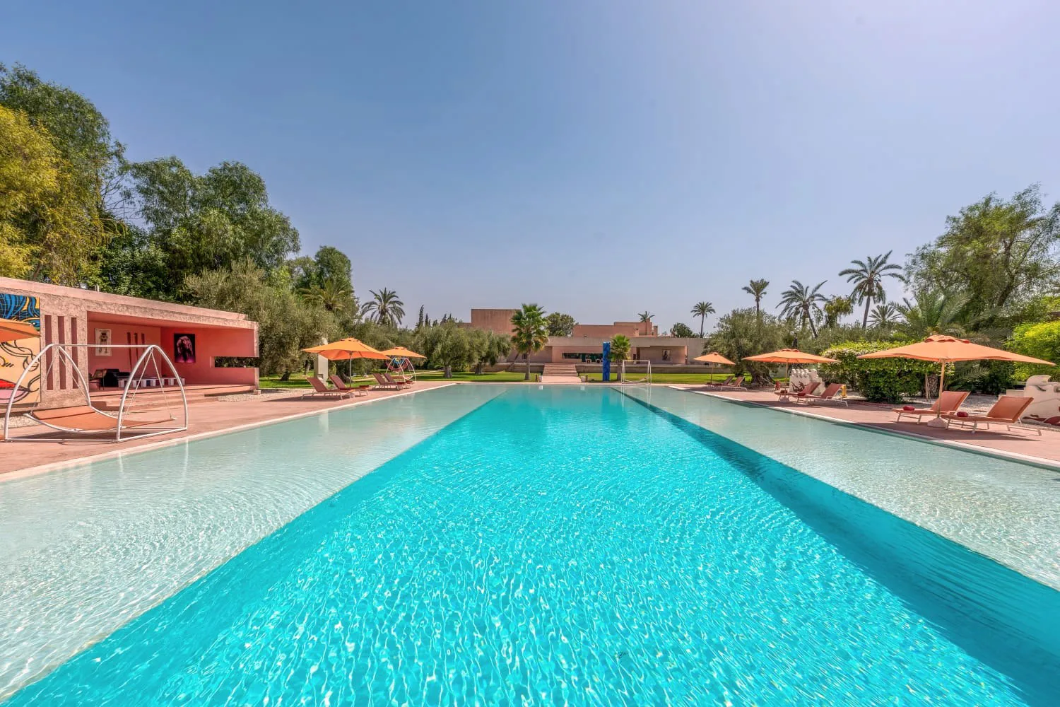 Villa Ianthe, private villa rental in the Palmeraie, Marrakech: large pool lined with sun loungers and parasols
