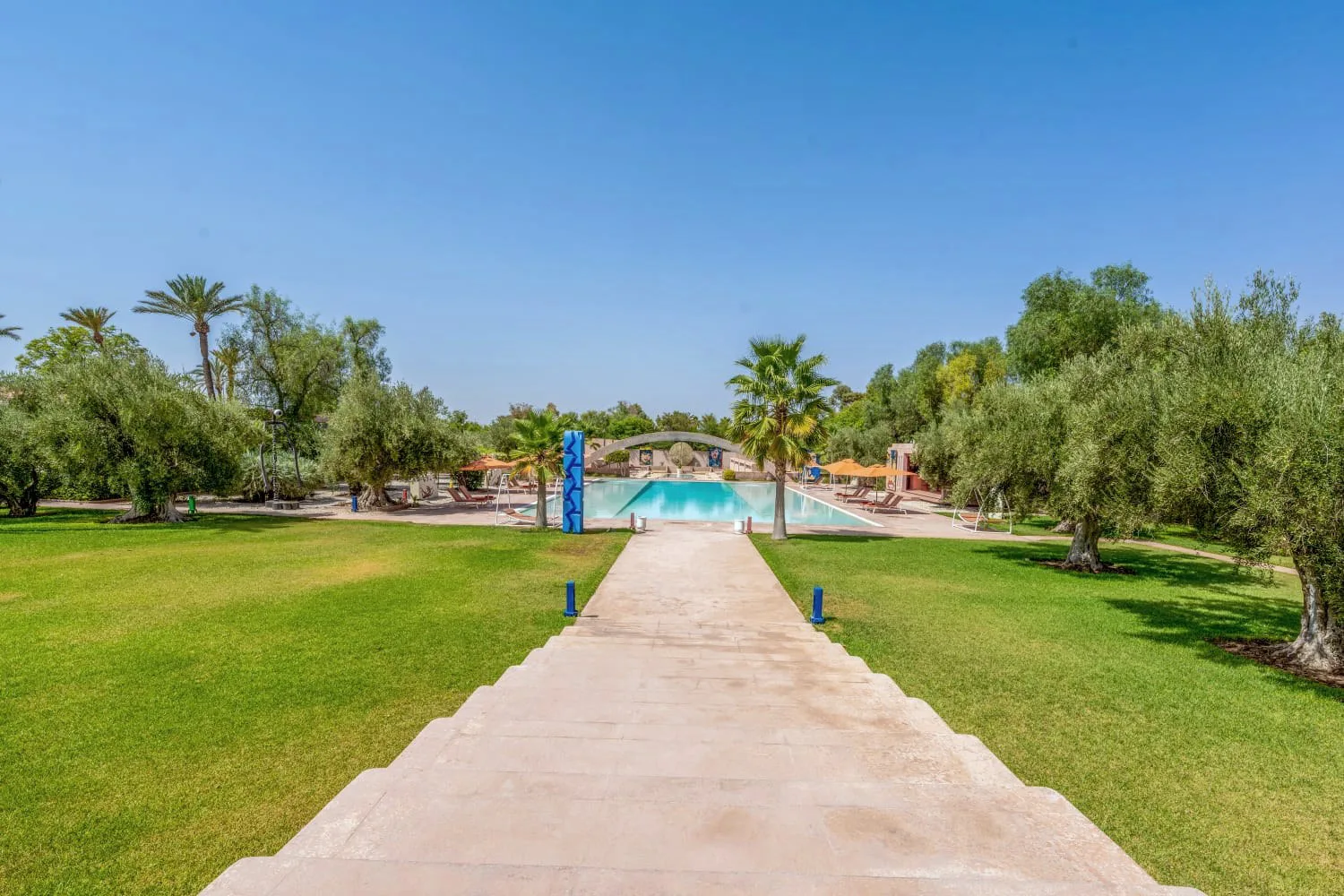 Villa Ianthe, private villa rental in the Palmeraie, Marrakech: walkway across the lawn through the olive groves