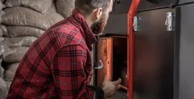 Technicien SR Stroh lors de l'entretien d'une chaudière à granulés à Phalsbourg