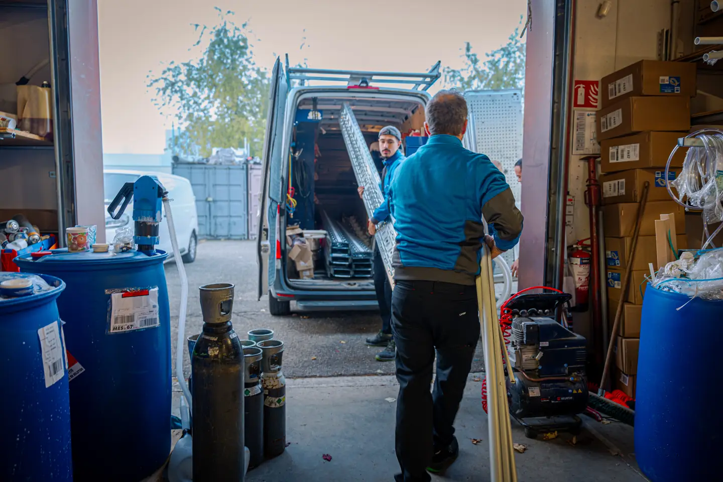 Technicien chargeant du matériel dans une camionnette depuis le dépôt