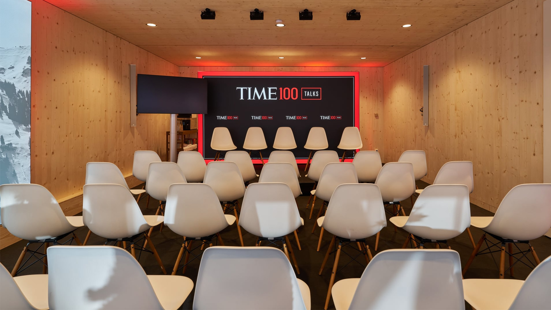 Bestuhlter TIME100 Talks Pavillon in Davos mit moderner Bühne, TIME100 Branding und minimalistischer Holzarchitektur vor Beginn der Paneldiskussion.