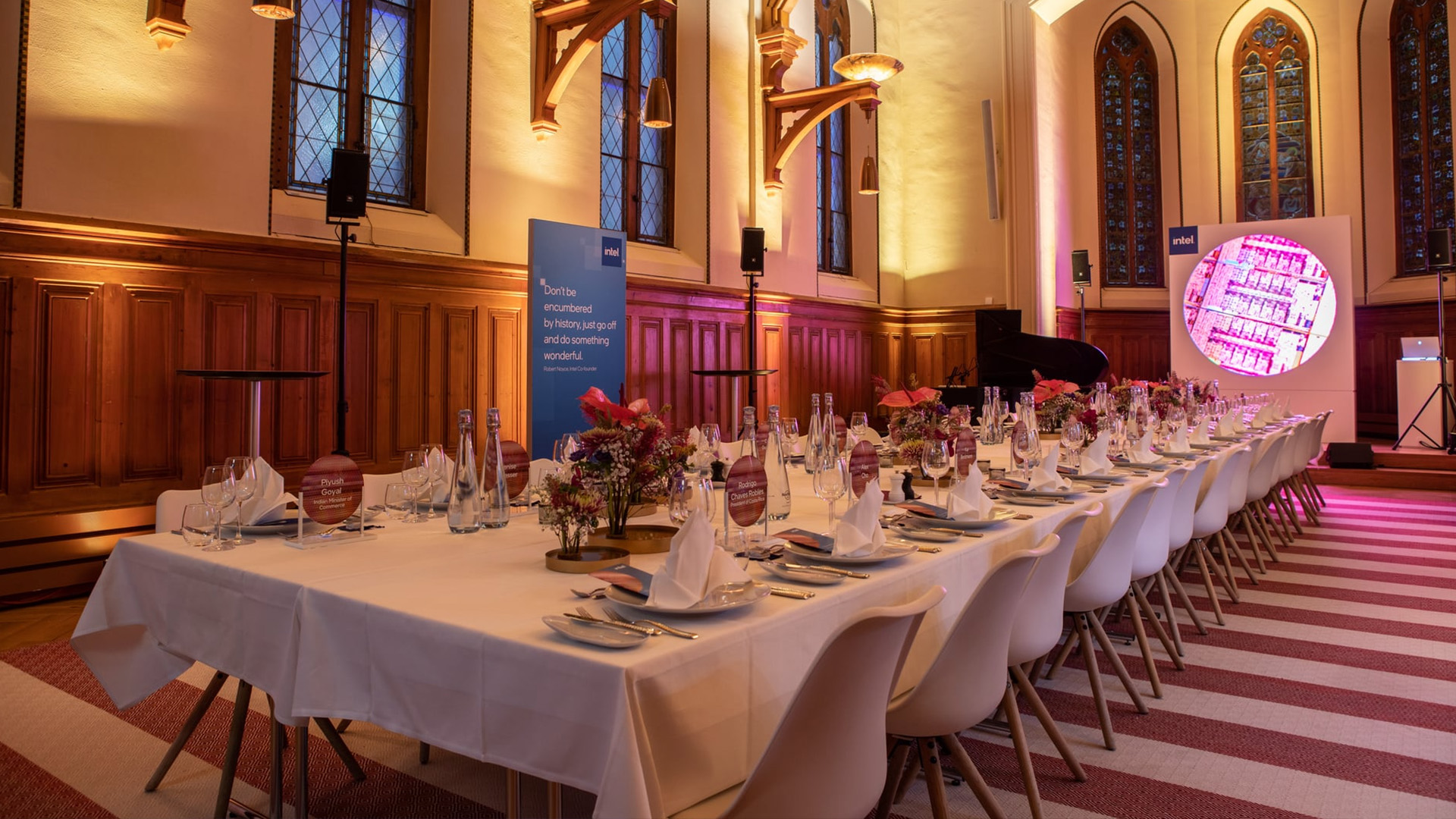 Festlich gedeckte Tafel in einer stilvoll beleuchteten Eventlocation mit historischen Kirchenfenstern und Intel-Branding.