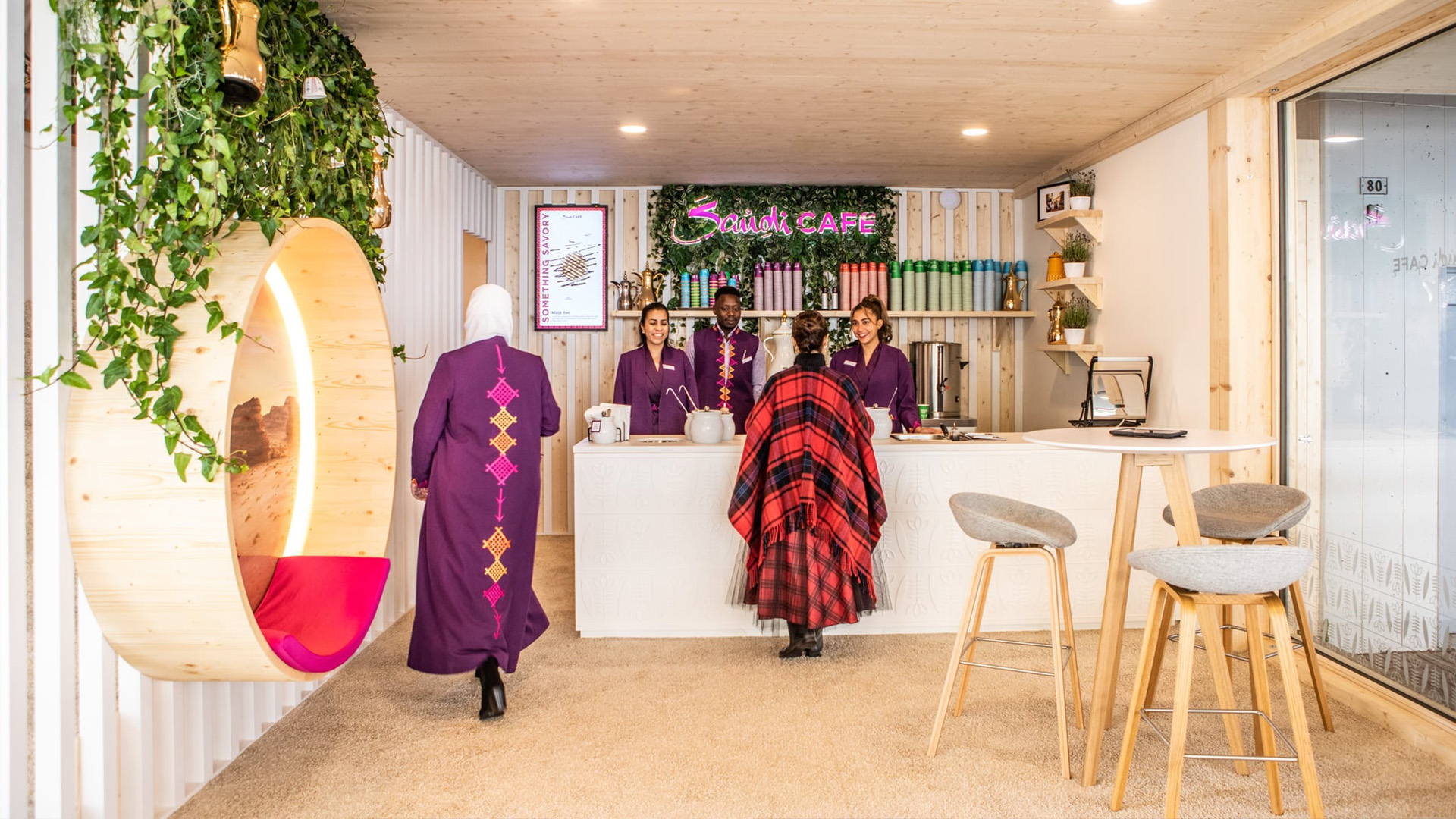 Besucher:innen im Saudi Café werden in einer einladenden Lounge mit traditionell inspiriertem Design und Kaffee-Bar empfangen.