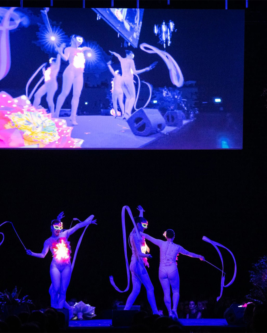 Tänzerinnen auf der Bühne mit Visuals und Lichtern