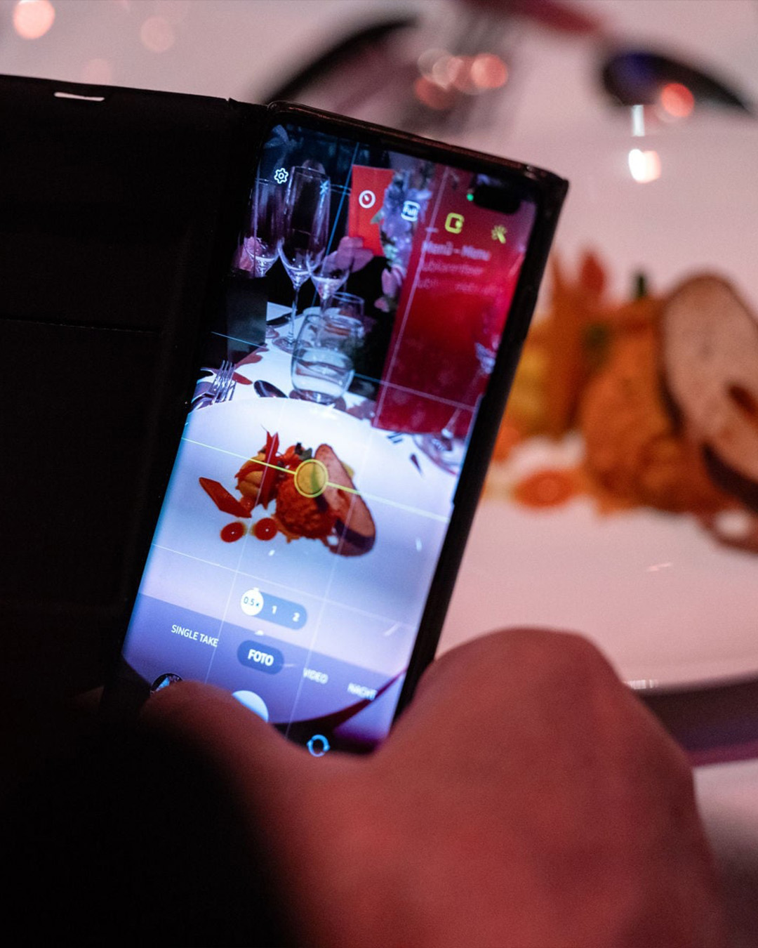Person macht ein Foto vom Essen mit dem Smartphone