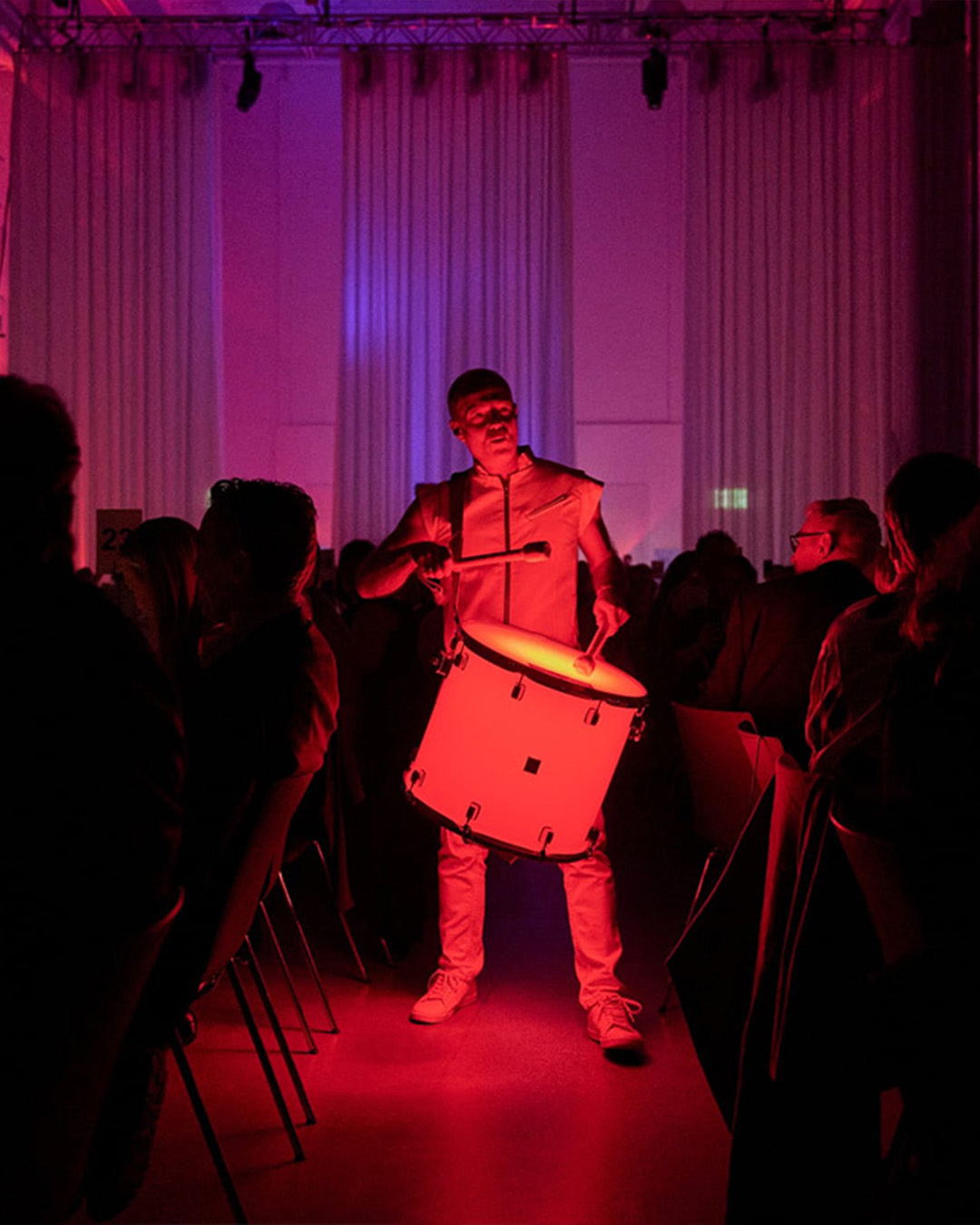 Musiker trommelt und Saal ist in rotes Licht gehüllt