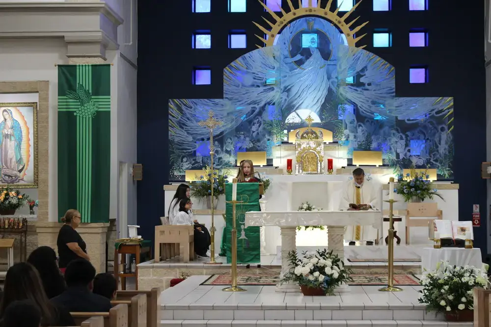 Student reading at lectern during Catholic school Mass ceremony