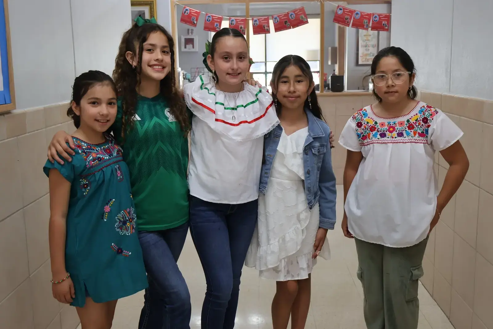 Five students posing in hallway during Hispanic Heritage celebration