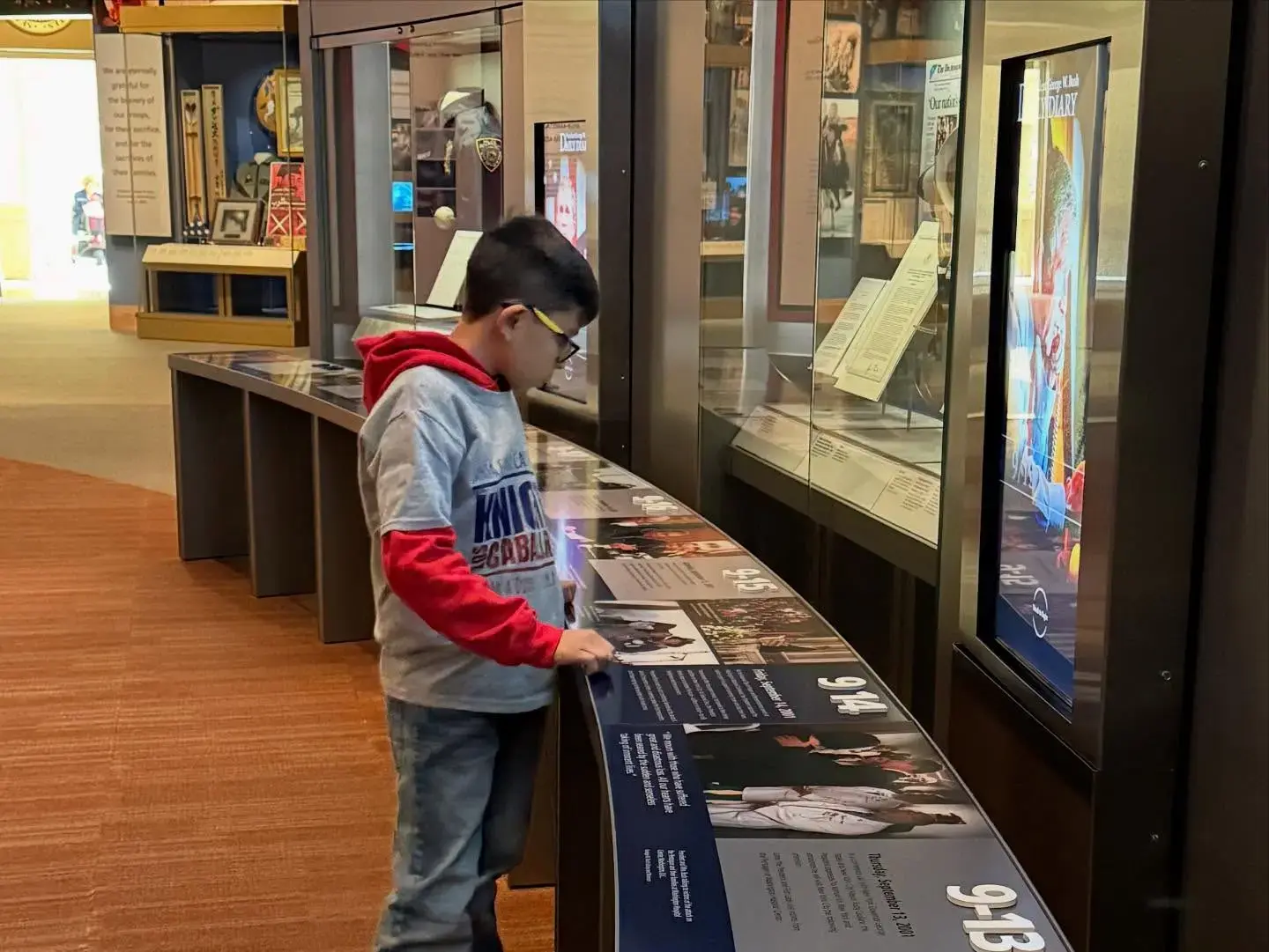 Student reading exhibit panels at a history museum display