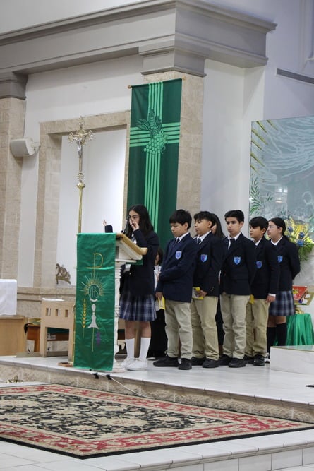 Students in uniform participating in a church Mass ceremony