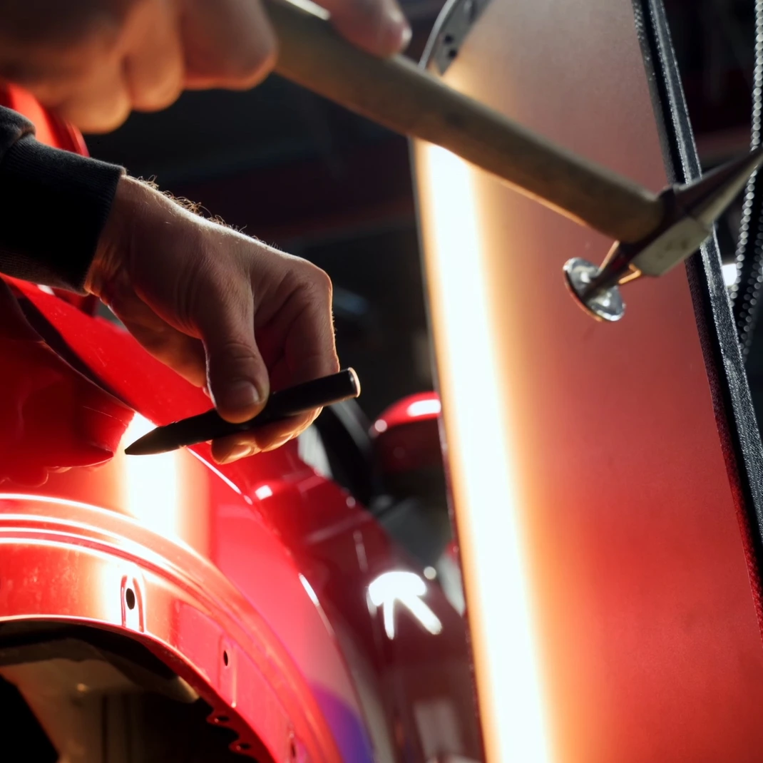 Technik podczas naprawy wgniecenia metodą PDR