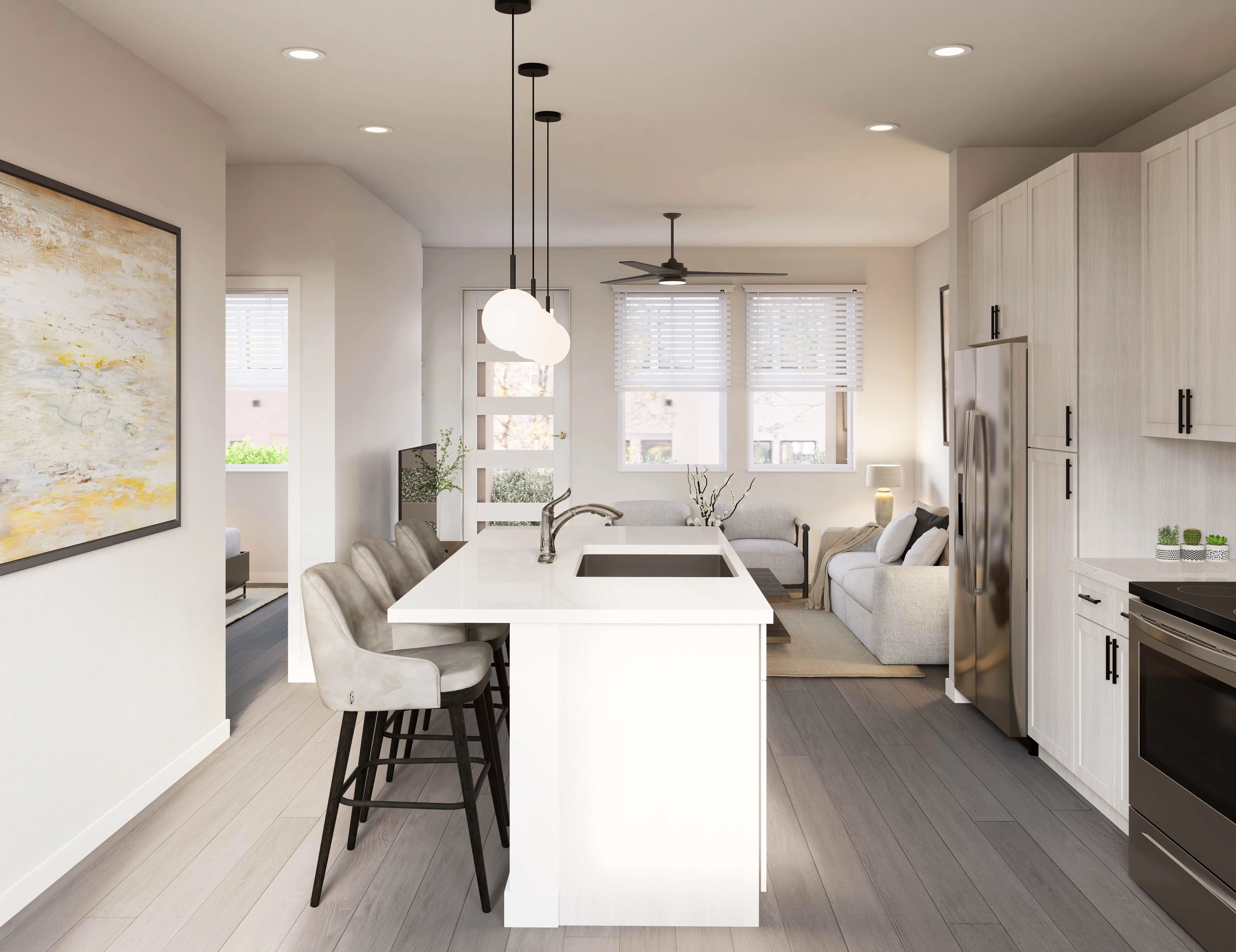 Home kitchen with a large white island with a sink and bar seating, looking into the living room, at The Eleanor Daytona Beach in Daytona Beach, Florida.