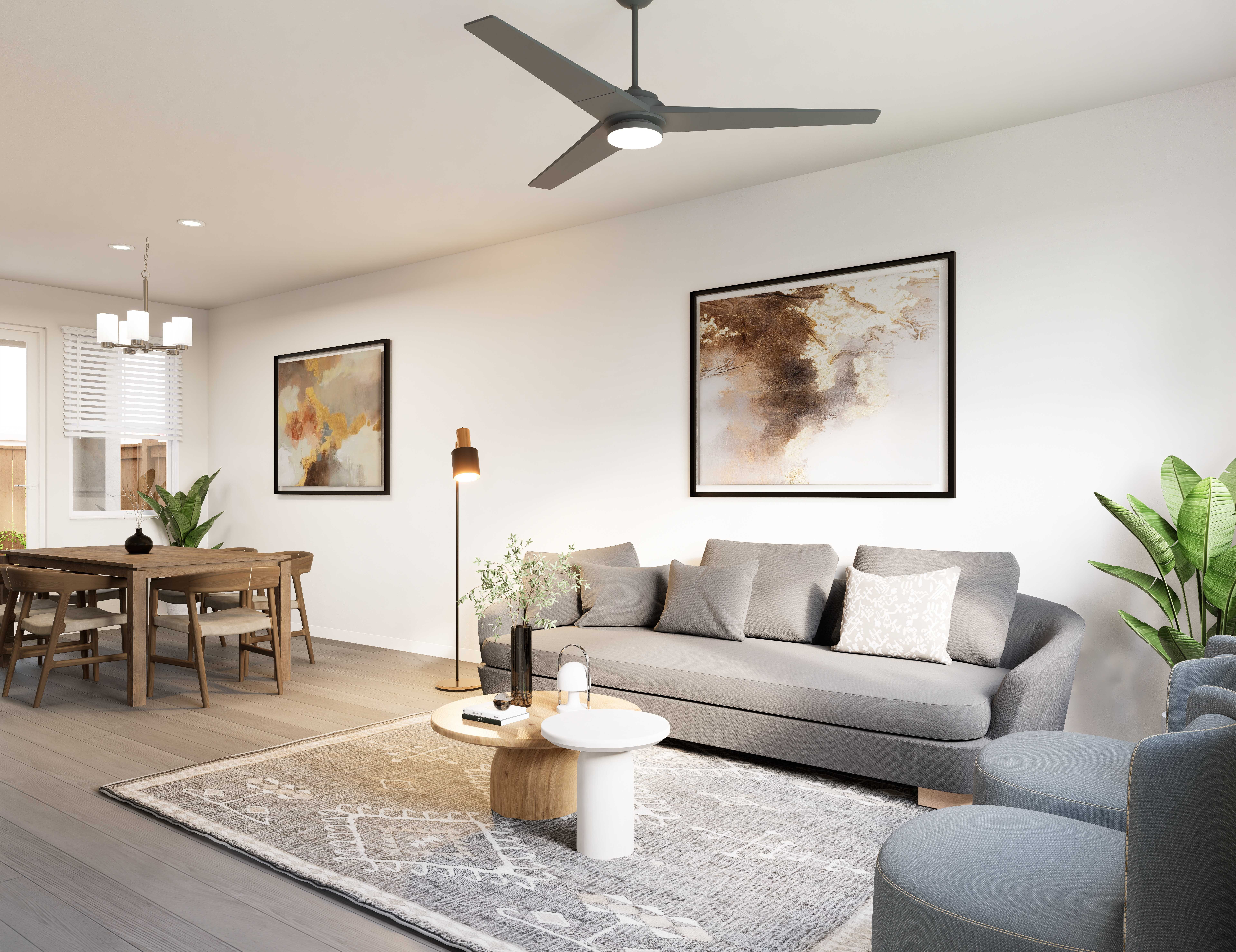 Spacious open-concept living and dining area with a modern sofa, round table, and ceiling fan at The Eleanor Daytona Beach in Daytona Beach, Florida.