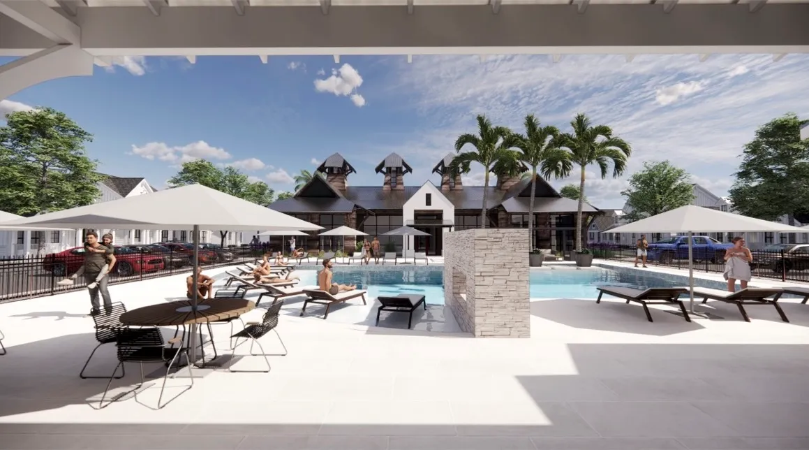 Resort-style swimming pool and sun deck with lounge chairs and umbrellas, next to the modern clubhouse at The Eleanor Daytona Beach in Daytona Beach, Florida.