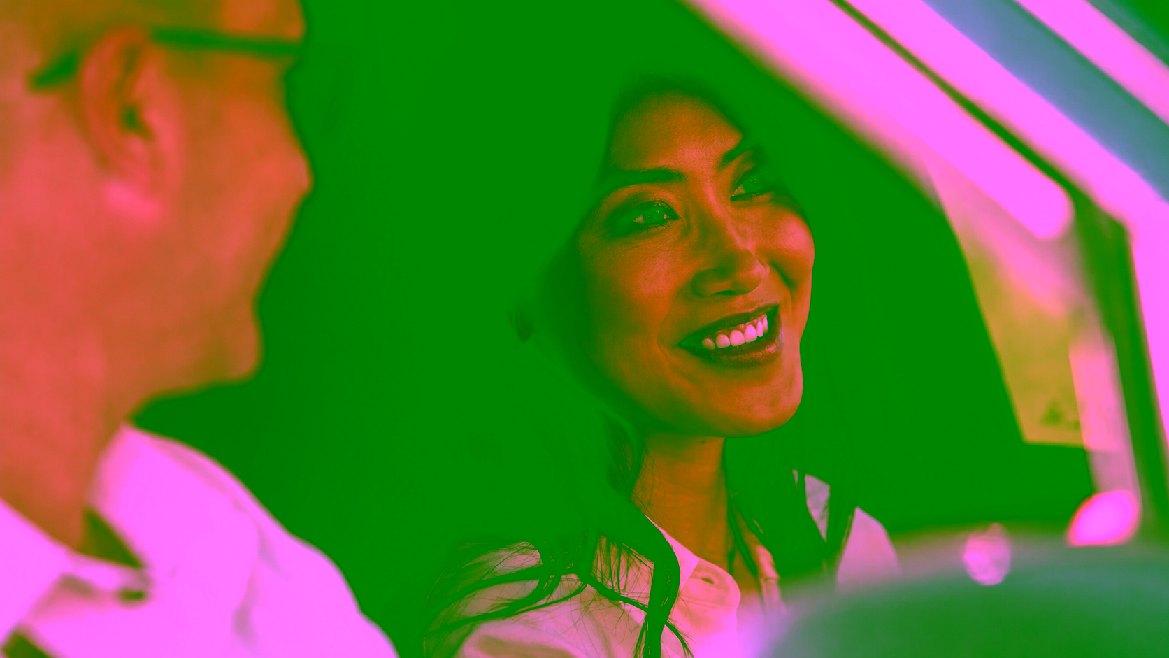 Femme assise dans une voiture souriant et échangeant avec un homme