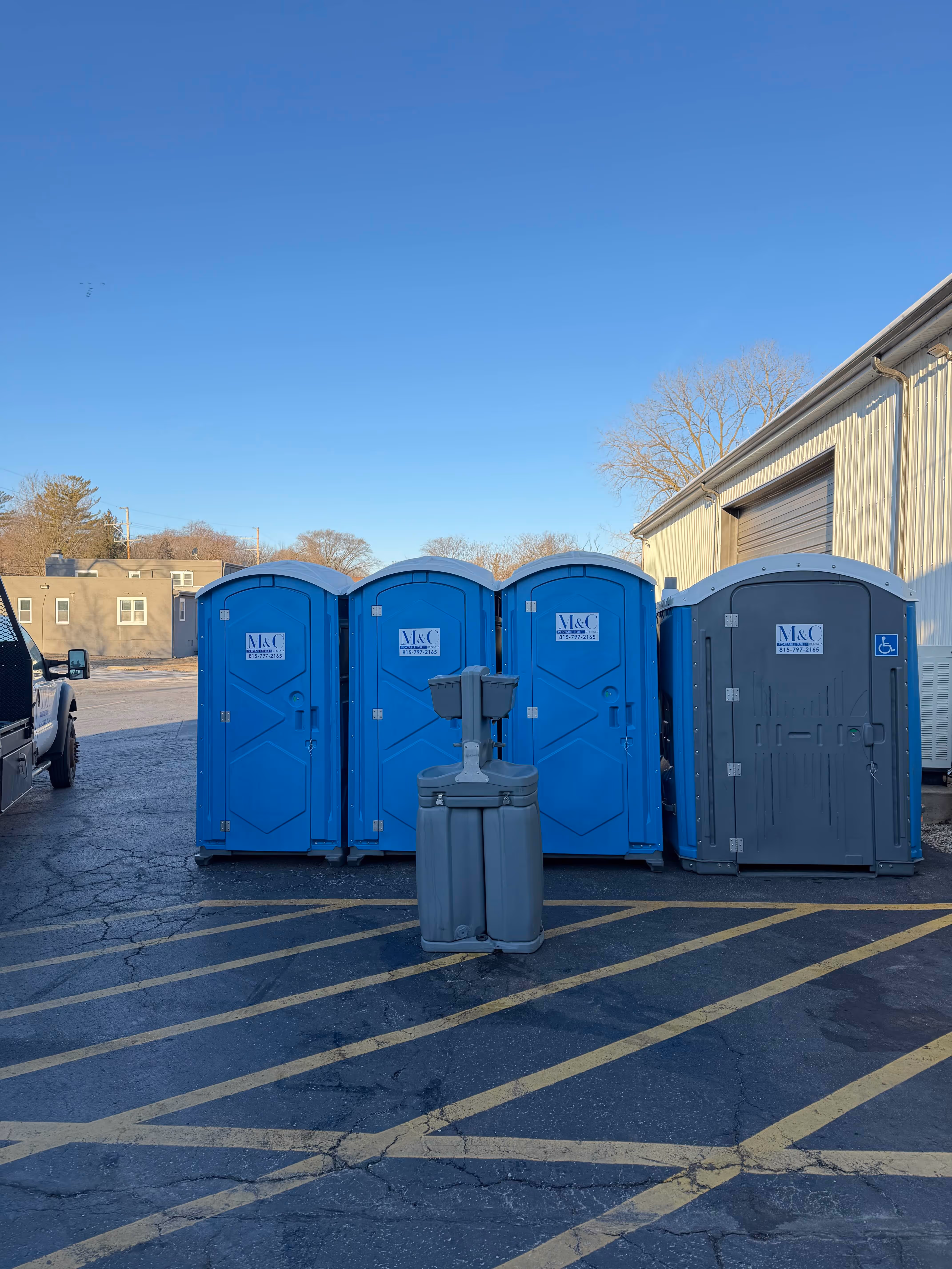 m-and-c-rentals-picture-in-parking-lot-with-blue-porta-potties