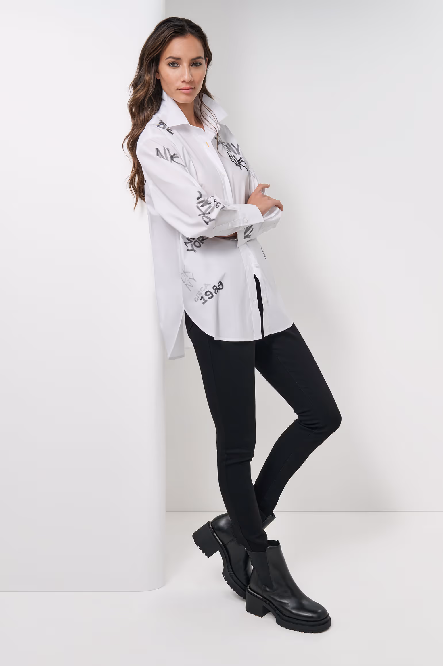 Model in a white blouse, black trousers and black boots