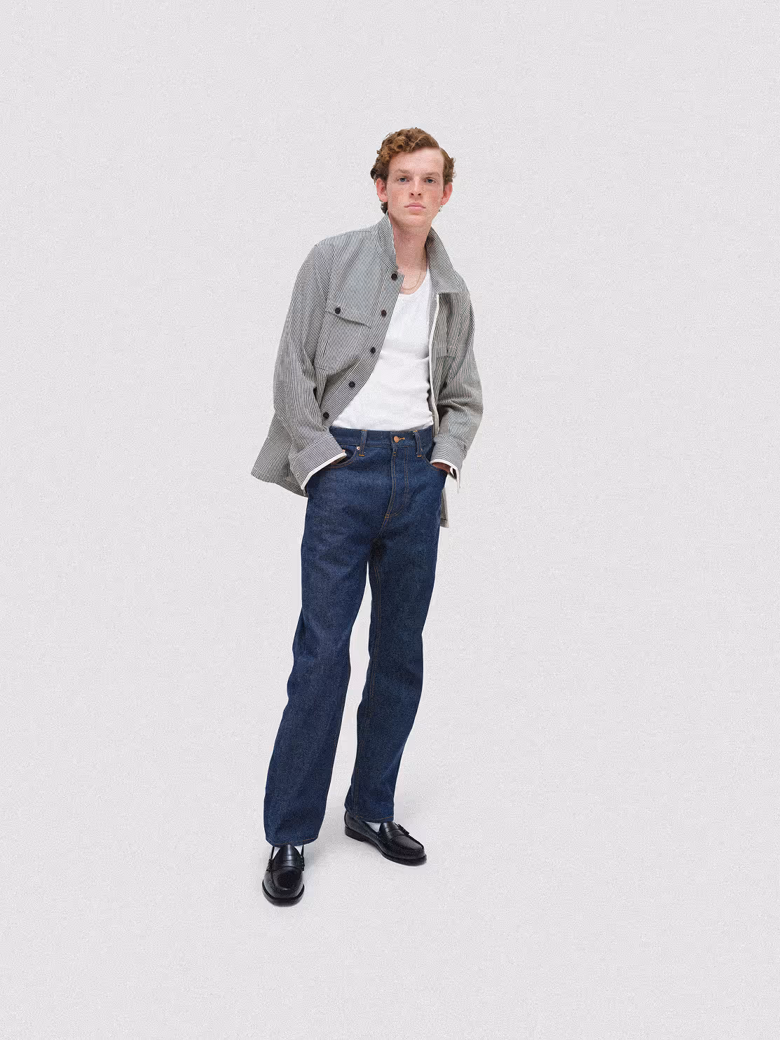 Model wearing a gray jacket and dark blue trousers
