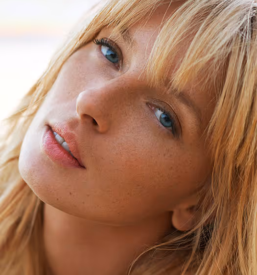 Close-up portrait of a blonde woman with freckles