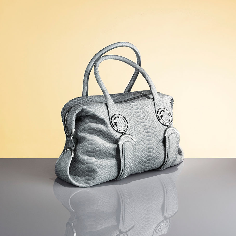 Gray textured handbag on a reflective surface