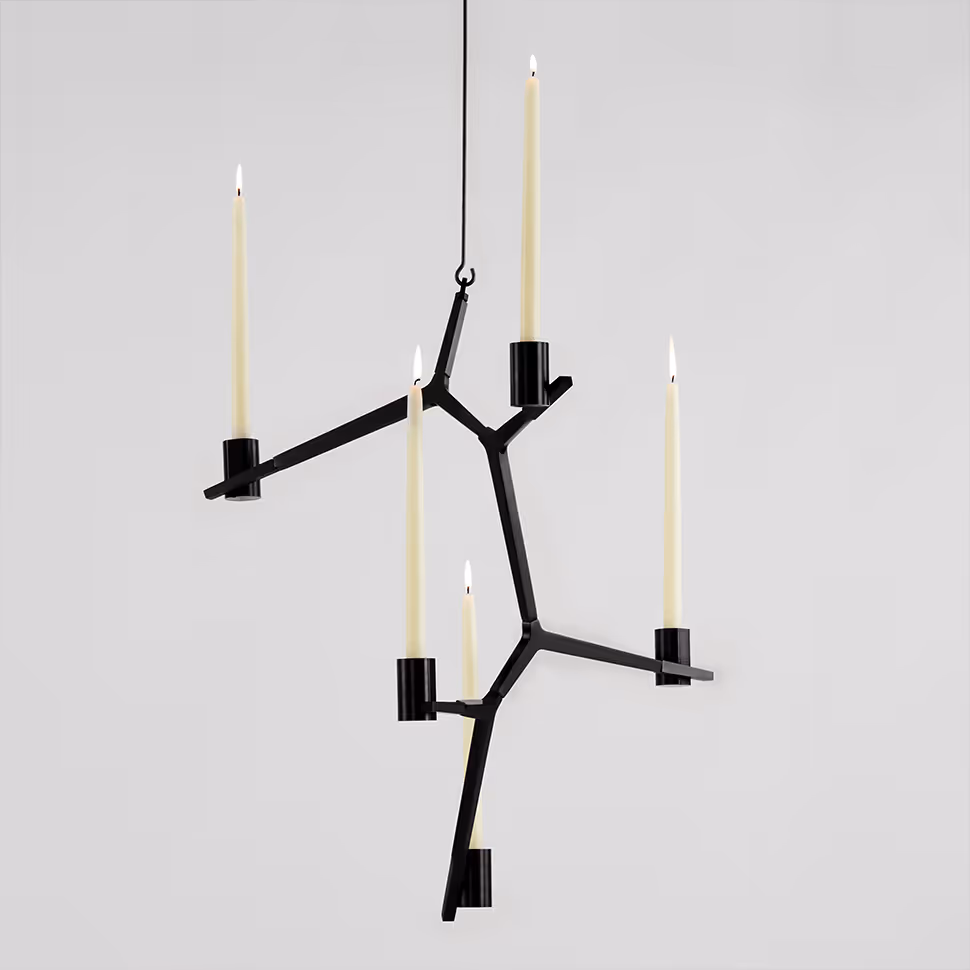 Black sculptural candleholder against a plain gray background before compositing