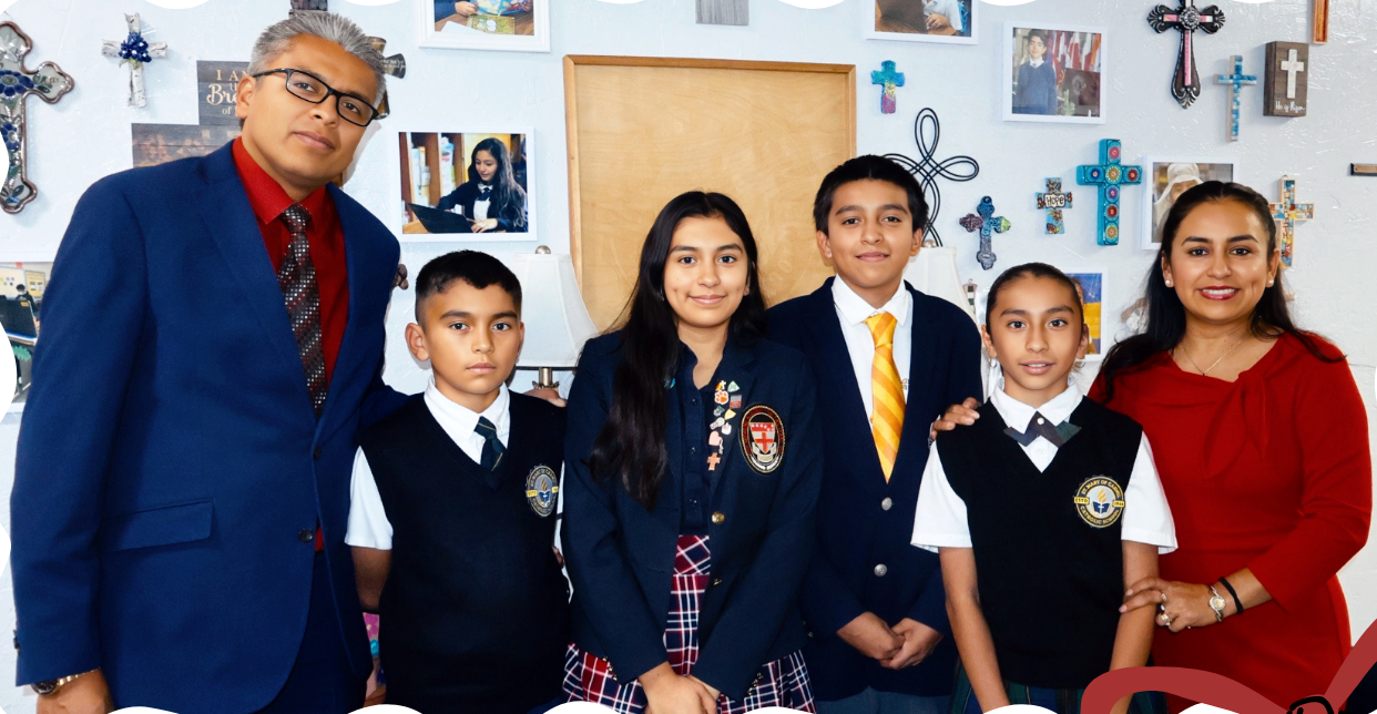 Four uniformed students posing with two adults in a classroom