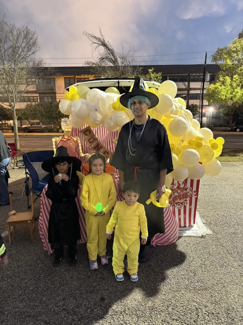 Adult and three children in Halloween costumes at trunk or treat event