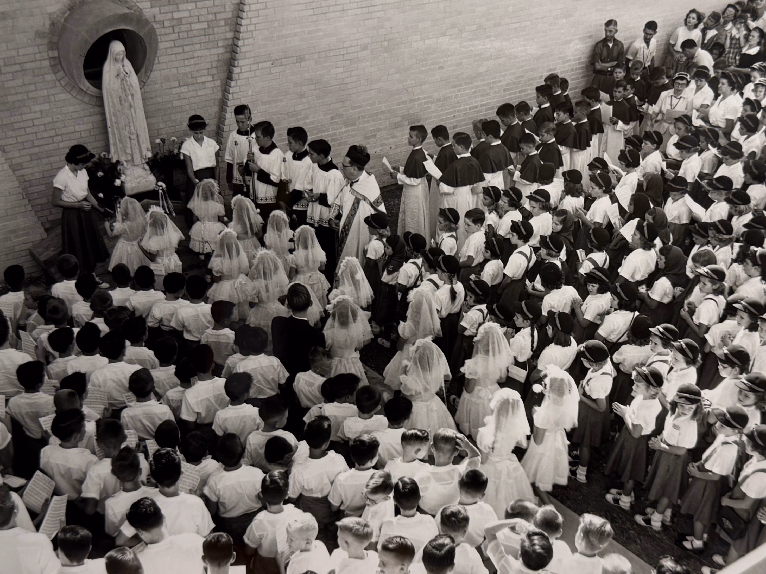 Students gathered outdoors for a Catholic First Communion ceremony