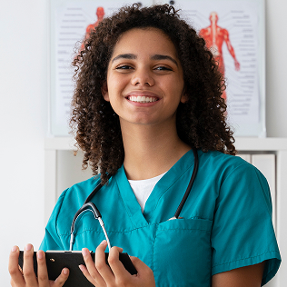 Smiling female healthcare professional in teal scrubs holding a tablet with anatomical charts in the background.