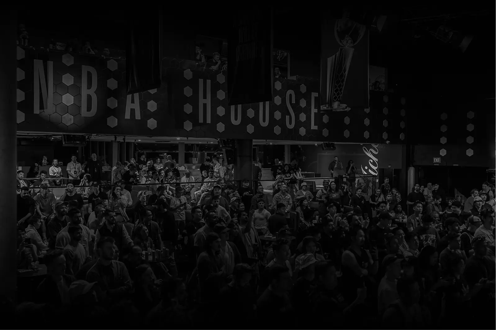 Large crowd of people gathered inside a venue with 'NBA HOUSE' displayed on the wall.