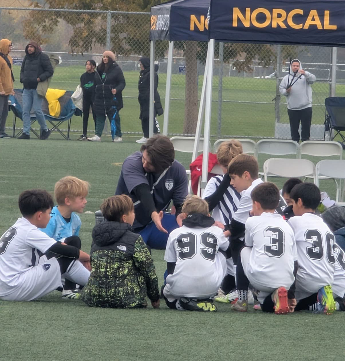 2015 team huddles around and listening to the coach