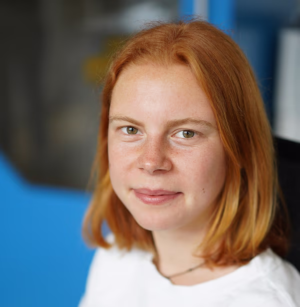 Patricia Sowa, Product Manager Hospital at voize, with red hair and a white shirt at the office.