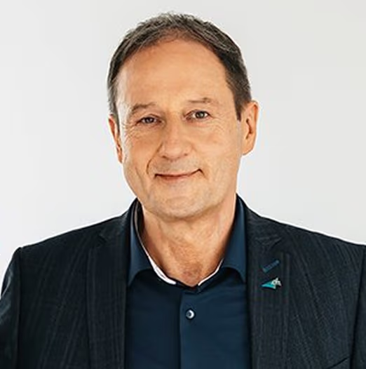 Männlicher Vertreter der Evangelischen Heimstiftung im blauen Sakko, lächelnd vor blauem Hintergrund.
