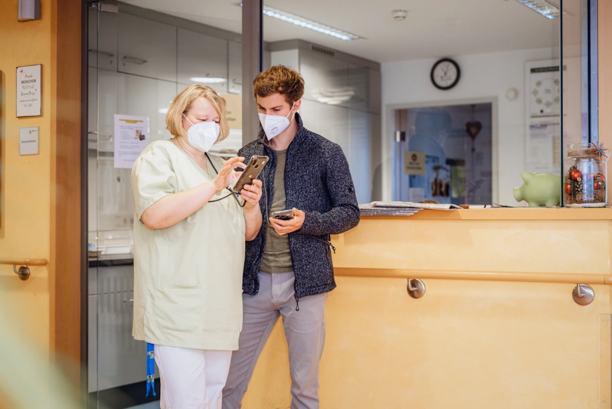 Pflegekraft im Gespräch mit Marcel Schmidberger, Gründer von voize.