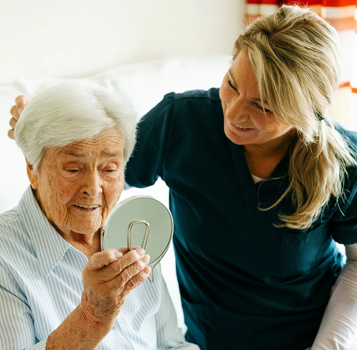 Pflegekraft in enger Begleitung einer Bewohnerin in der ambulanten Pflege.