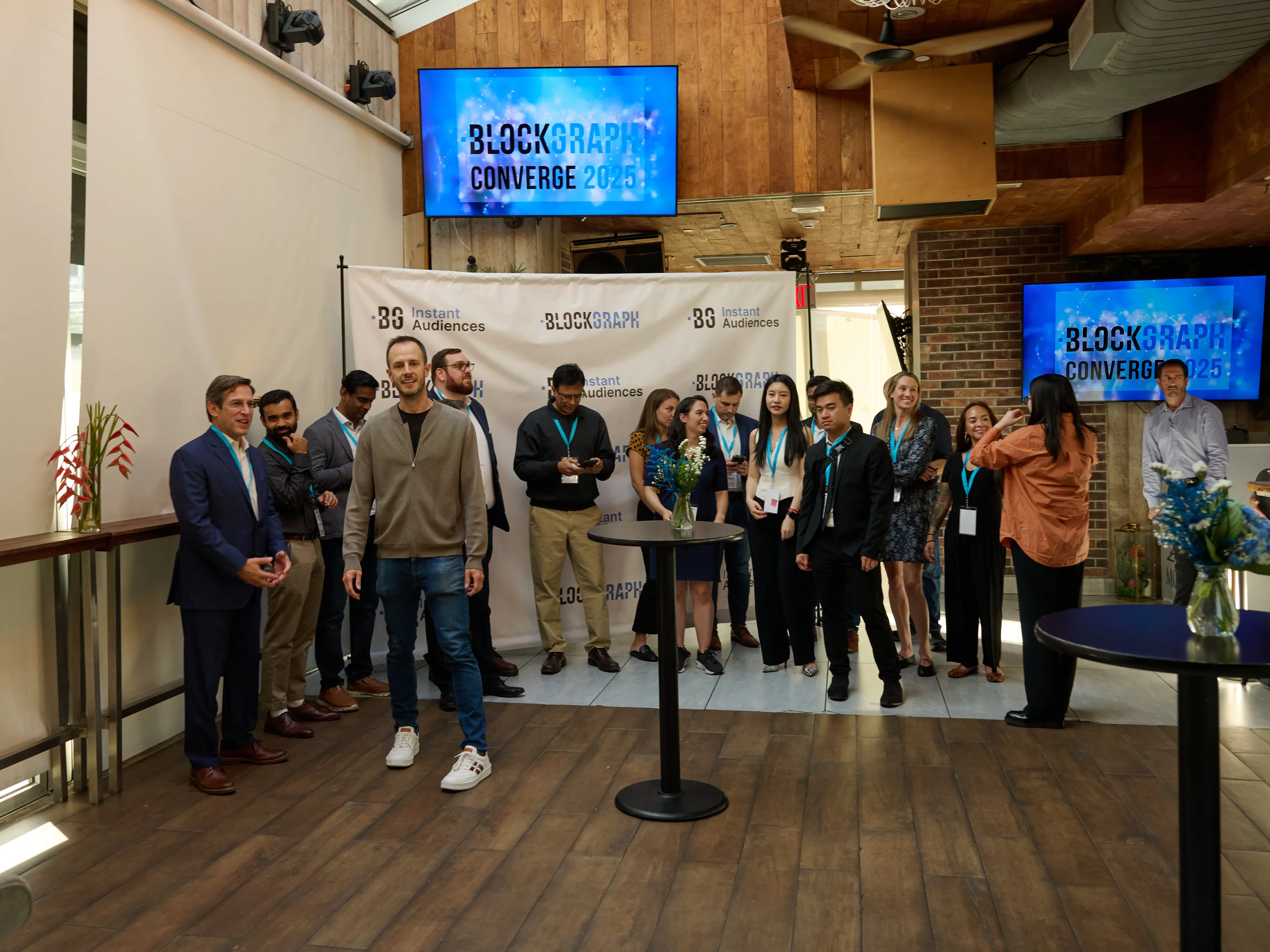 Group of people standing in front of a Blockgraph Converge 2025 banner at an indoor event.