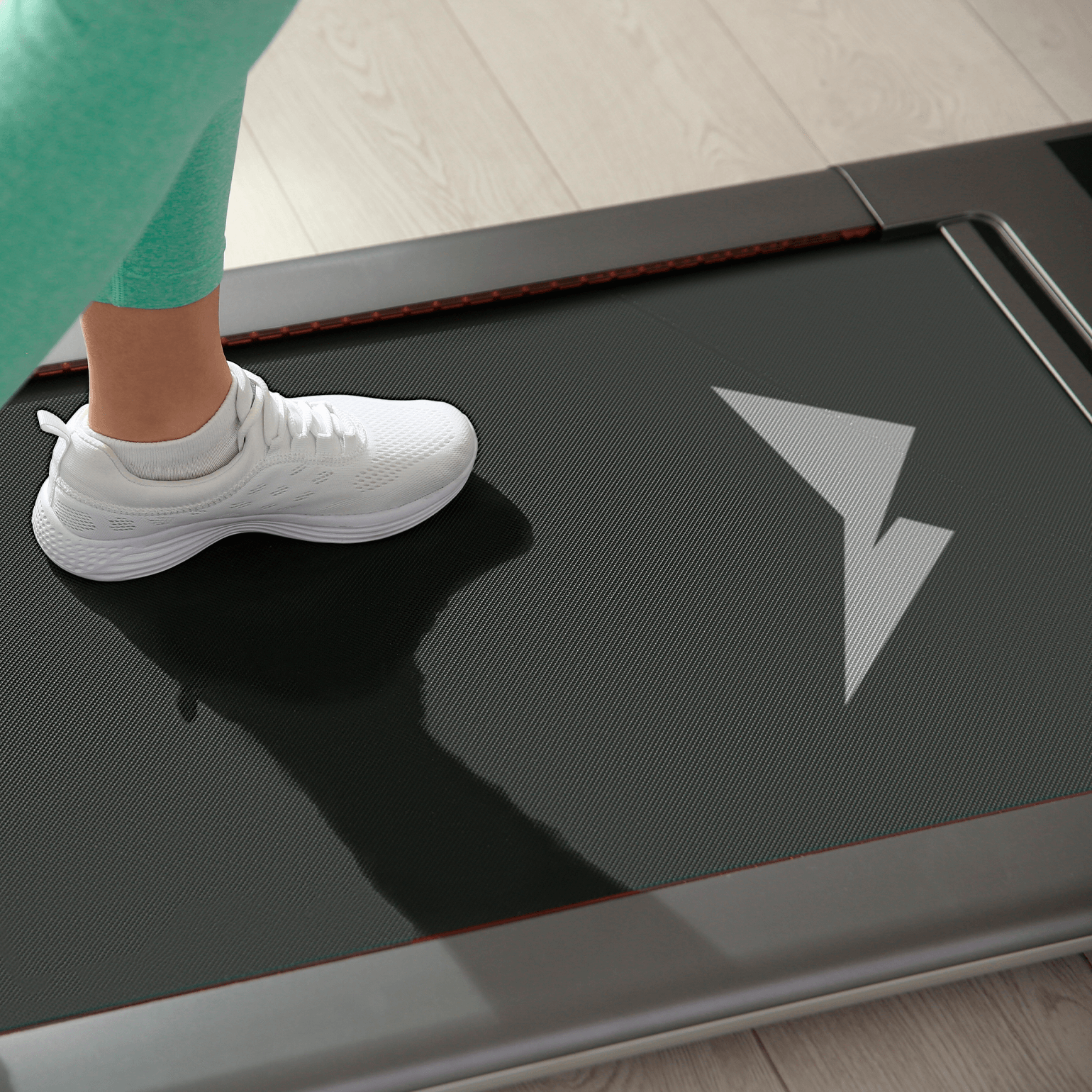 Detalle de zapatilla deportiva blanca sobre caminadora con logotipo de Medicathlon aplicado en la superficie de la banda rodante fotografía de producto y aplicación de identidad visual para marca colombiana de deporte y salud por Intacto Studio estudio de branding en Medellín y Bogotá Colombia.