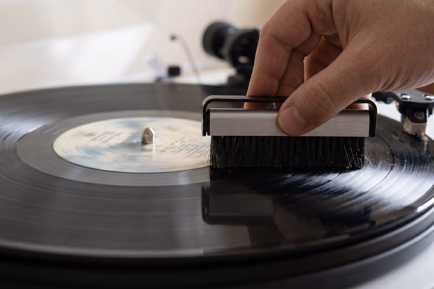 Carbon fibre brush being used to clean dust from a vinyl record
