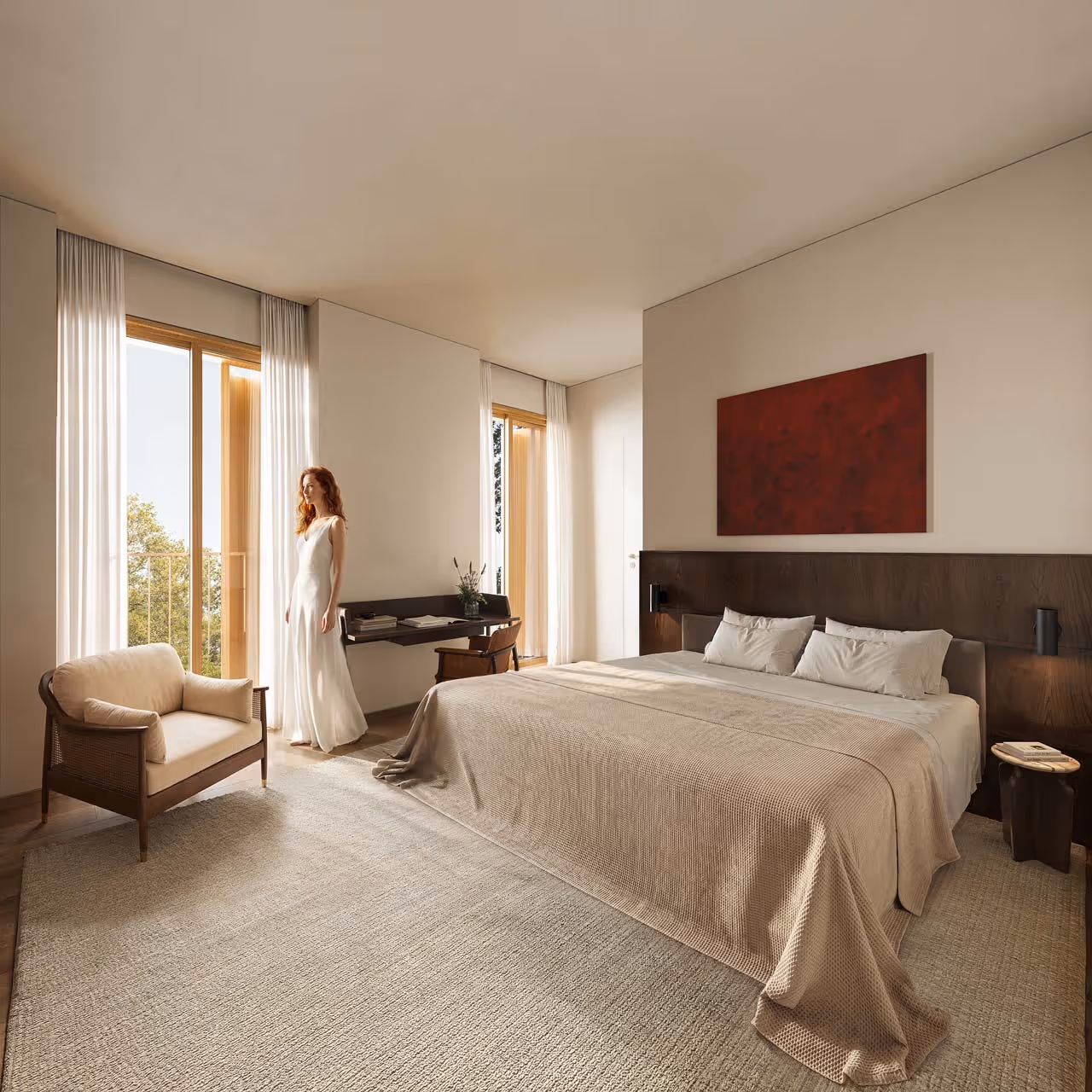 Quarto moderno com cama grande, poltrona, escritorio, parede branca, quadro vermelho e mulher de vestido branco.