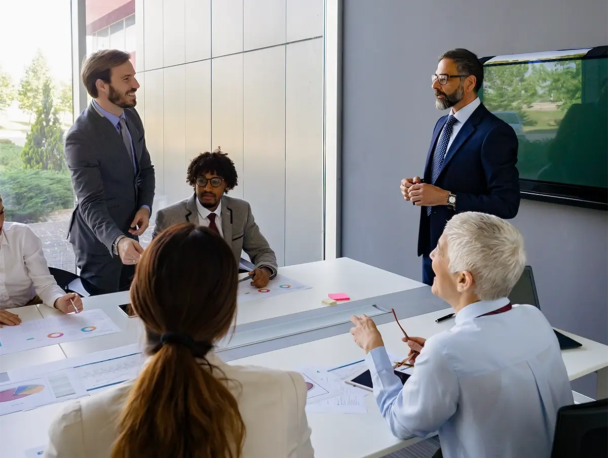 Business team gathered in a meeting room during a presentation and discussion around a table