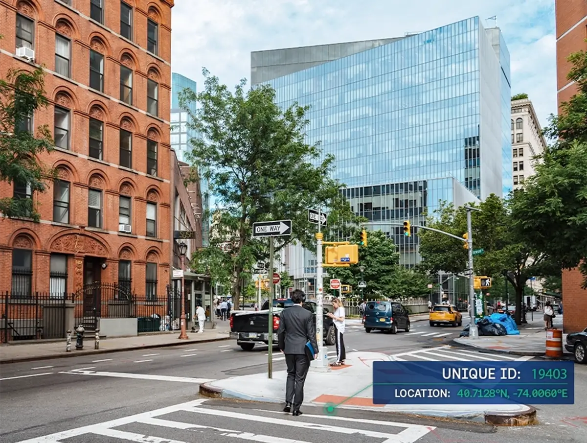 New York street corner with brick and glass buildings, pedestrians, traffic, and a digital overlay showing a unique ID and location coordinates