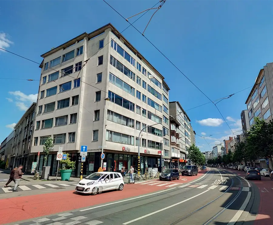 European city street with tram tracks, red bike lanes, pedestrians, cars, and mixed historic and modern buildings